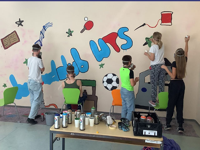 Graffiti-Projekt an der Weiltalschule verschönert das “Haus des Ganztags”.